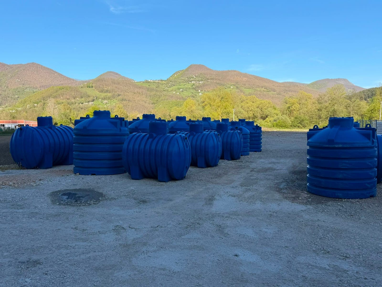 Plastične cisterne na platou, brda u pozadini